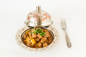 The Sacrifice Festival Food From Turkish Cuisine is Tas Kebabi stew made with beef in vintage plate with fork