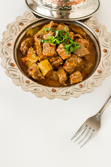 The Sacrifice Festival Food From Turkish Cuisine is Tas Kebabi stew made with beef in vintage plate with fork,vertical image