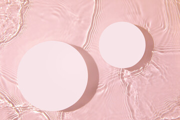 Two empty white circle podiums on transparent clear pink water texture with splashes and waves in...