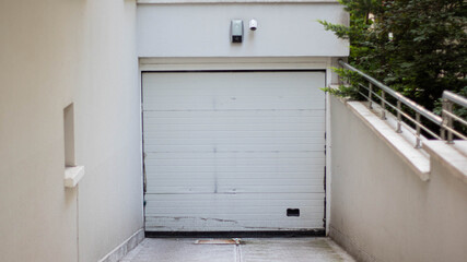 A car garage with a white door, a secure car garage