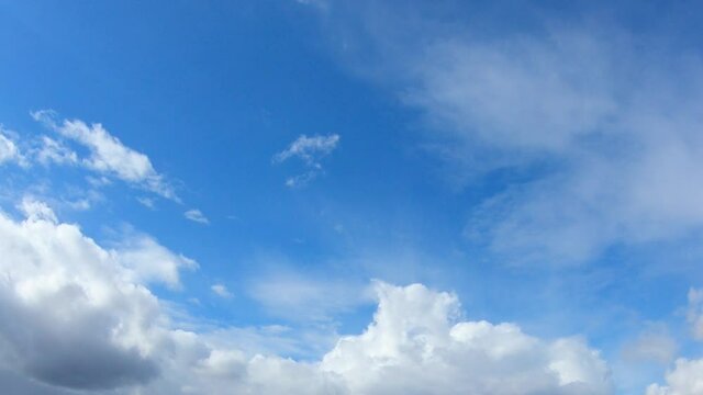 Dense cumulus clouds against the clear blue sky. Nice weather, time-lapse.
