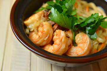 noodles with shrimp. dark bowl on wooden concrete background japan style concept closeup