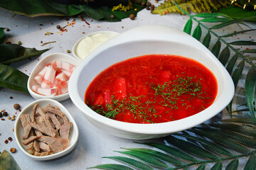 Traditional Ukrainian Russian borsch with with sour cream and meat. Beetroot soup. Plate of red beet root soup borsch on white table. Traditional Ukraine food cuisine. - Image
