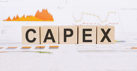 On a light background, graphs, diagrams and wooden cubes with the word CAPEX - Capital Expenditure.