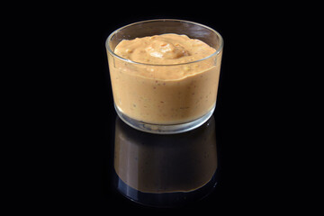 bowl of sauce isolated on black background with reflection