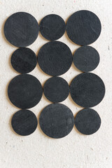 close up of black discs or circles on millboard - photographed from above in a top down style 