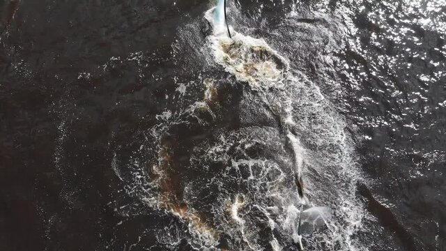 Water sports - a man flying around over the water on the flyboard in circles - aerial view