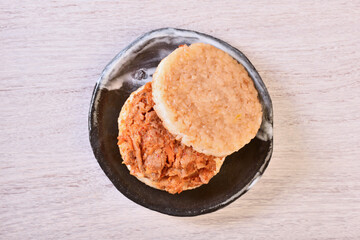 Rice burger with kimchi pork on a black plate 