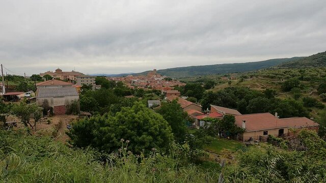 A landscape of village houses on a greenfield under a gloomy sky in 4K