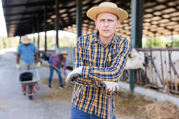 Portrait of confident young adult man engaged in livestock breeding farm