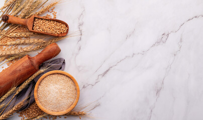 Wheat ears and wheat grains set up on marble background. Top view and copy space