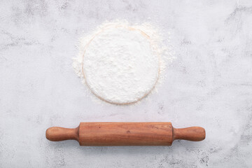 Fresh homemade yeast dough resting on whote concreate background flat lay with rolling pin.