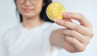 Woman holding a Bitcoin token. Cryptocurrency is a virtual or digital money which takes the form of...