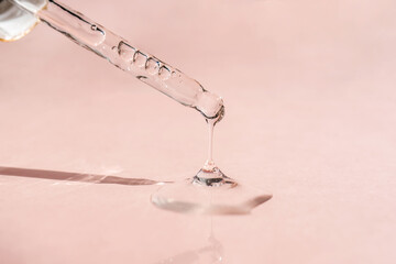 A drop of cosmetic oil falls from the pipette
