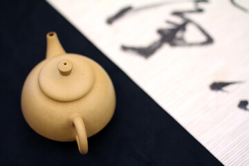 On the black and white contrasting base map, a simple earthenware teapot is placed, full of the natural and comfortable tea culture and Zen style of the East