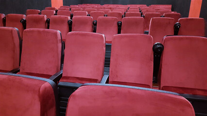Red chairs in the cinema hall before the start of the session.