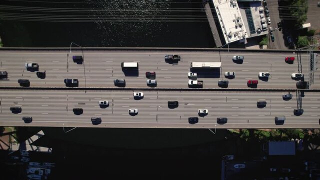 Drone Overhead Cars Commuting Across Bridge Over Blue Water