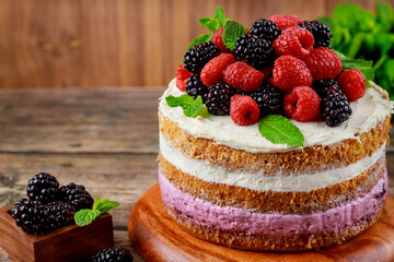 Delicious berry cake decorated with fresh raspberries and blackberries.