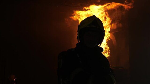 Portrait of firefighter, Fire flames burning strong lpg gas pipe end at container. Gas pipeline leaks, gas explosion bursting through air on the ceiling