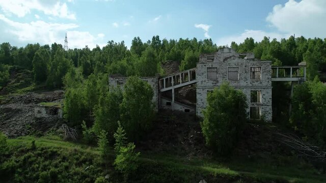 old factory buildings and buildings without a roof made of white brick in nature in a beautiful atmospheric but gloomy and quiet location of ules and the mountains. Tuimsky abandoned mine in Russia