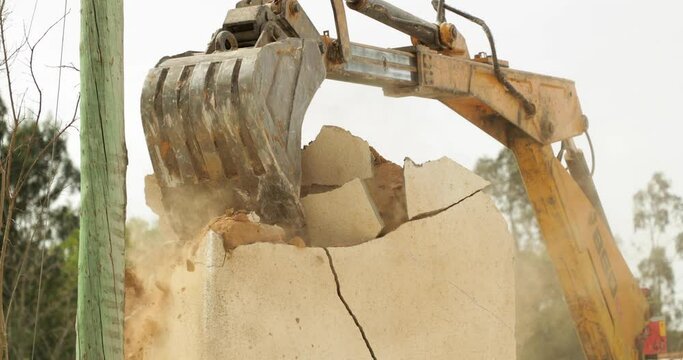 Heavy Machinery Demolishing Concrete Wall Of A House. - wide shot