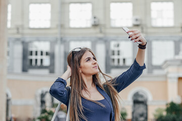 Beautiful female making selfie in urban city