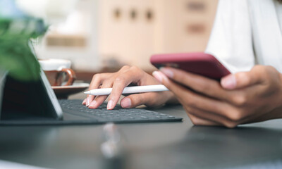 Cropped shot of woman hand holding digital pen and working on computer while sitting at office.