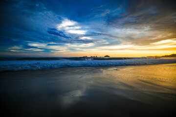 Obraz premium landscape with sea sunset on beach, clouds, sun and island. Beautiful sunrise over the sea, people walking,Panorama of Beach, Ocean, People