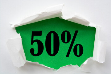 Torn paper with fifty percent off words behind it