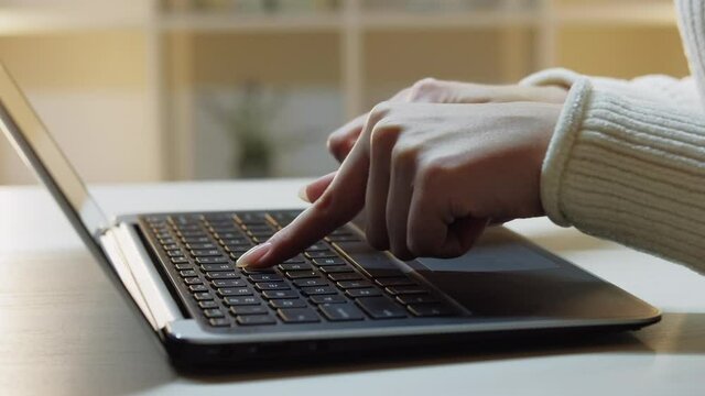 Female beginner. Computer skill. Study practicing. Digital technology. Woman hands slowly typing one finger on laptop in light room interior background.