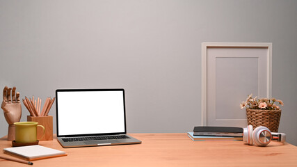 Computer laptop with white screen at designer workspace.