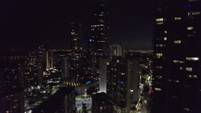 Aerial view around high rise buildings, night in Miami, Florida - circling, drone shot