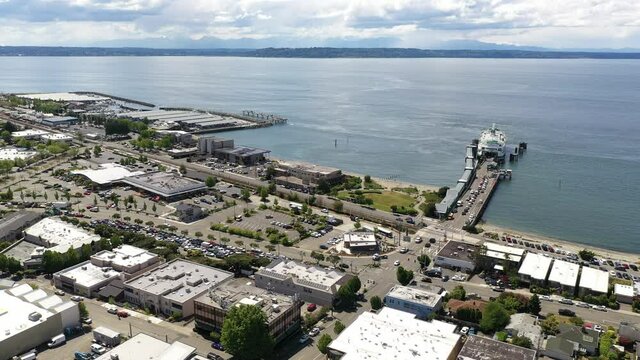 Cinematic 4K drone trucking footage of the downtown Edmonds commercial area, Kingston ferry terminal, Port of Edmonds, waterfront marina, near Seattle, Washington, in Snohomish County