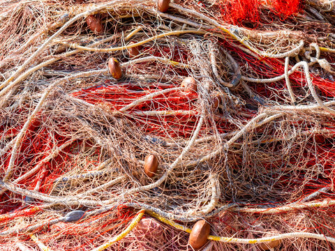 Net of fishermen huddled on the quay of the harbor or inside the boats. Background of colorful fishing nets. Close up view of fishing net
