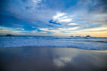 landscape with sea sunset on beach, clouds, sun and island.
Beautiful sunrise over the sea, people walking,Panorama of Beach, Ocean, People