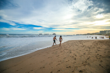 landscape with sea sunset on beach, clouds, sun and island.
Beautiful sunrise over the sea, people walking,Panorama of Beach, Ocean, People