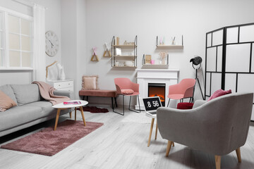 Stylish interior of modern living room with fireplace and laptop