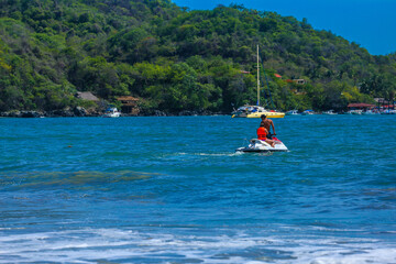 Fototapeta na wymiar Water motorcycle in blue sea on clear sunny day. Water bike on waves of sea, Homem com jet sky na água
