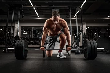 Fotobehang Sportschool Athlete, man doing deadlift with a barbell young athlete preparing for a heavy weight barbell lifting workout  © Georgii