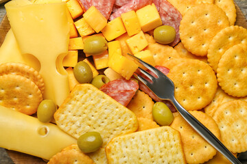 Tasty crackers with cheese and snacks, closeup