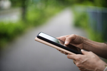 歩道でスマホを見る女性
