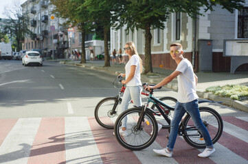 Fototapeta na wymiar Couple riding bikes in summer city