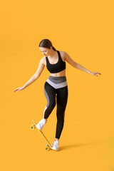 Fototapeta na wymiar Sporty young woman with skateboard on color background