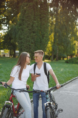 Obraz premium Couple riding bikes in summer forest