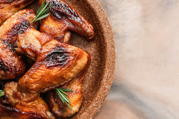Plate with roasted chicken wings on grunge background
