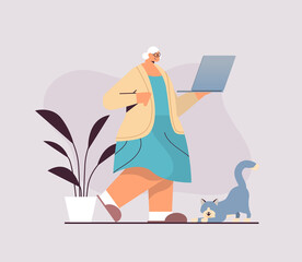 senior woman using laptop grandmother relaxing at home social media network concept full length