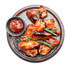 Board with roasted chicken wings and sauce on white background