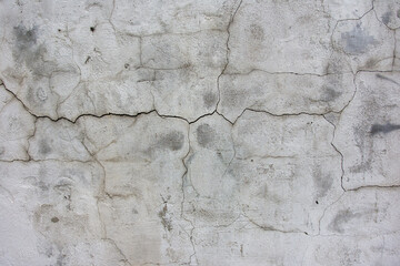 gray wall with many cracks use for background
