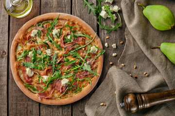 Pizza with cured ham, pear, blue cheese, pine nuts, arugula