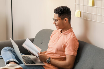 Young African-American guy studying online at home